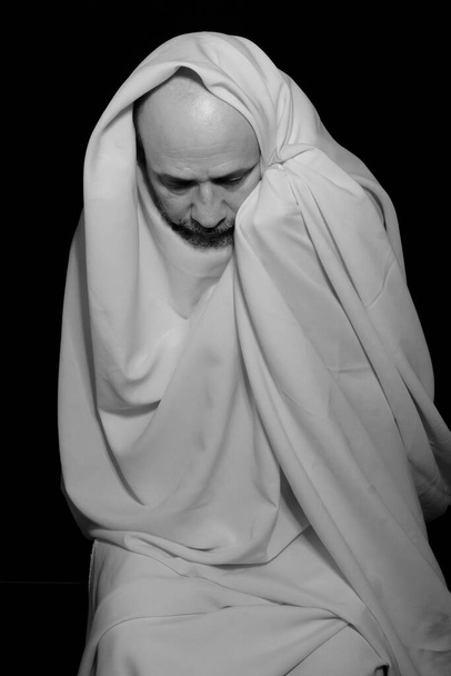 Man covered with cloth against black background. Salvador, Bahia, Brazil. - Photo, Image