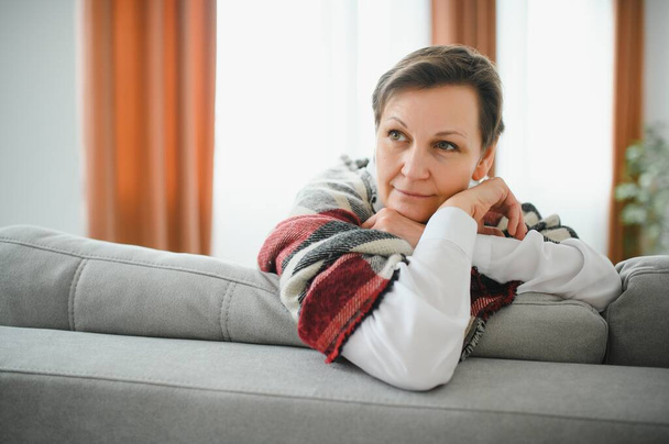 Mature Woman. Beautiful Healthy Middle Age Female Sitting On Sofa At Home. Beauty And Comfort Concept. - Foto, Bild