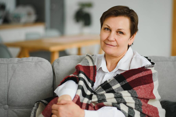 Mature Woman. Beautiful Healthy Middle Age Female Sitting On Sofa At Home. Beauty And Comfort Concept. - Foto, Bild