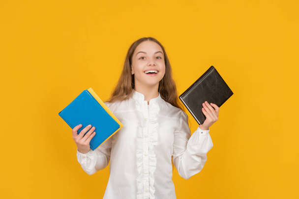 happy kid holding school homework on yellow background, back to school - Fotoğraf, Görsel