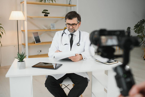 Handsome male doctor recording video for medical blog - Fotoğraf, Görsel