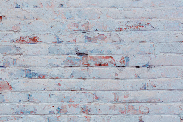 Текстура кирпичной стены с трещинами и царапинами, которые могут быть использованы в качестве фона - Фото, изображение
