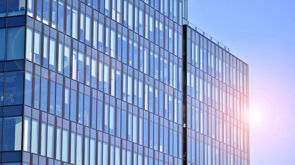 Γυάλινο κτίριο με διάφανη πρόσοψη του κτιρίου και γαλάζιο ουρανό. Δομικός γυάλινος τοίχος που αντανακλά μπλε ουρανό. Αφηρημένο κομμάτι σύγχρονης αρχιτεκτονικής. Σύγχρονο αρχιτεκτονικό υπόβαθρο. - Φωτογραφία, εικόνα