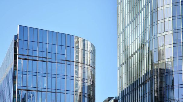 Γυάλινο κτίριο με διάφανη πρόσοψη του κτιρίου και γαλάζιο ουρανό. Δομικός γυάλινος τοίχος που αντανακλά μπλε ουρανό. Αφηρημένο κομμάτι σύγχρονης αρχιτεκτονικής. Σύγχρονο αρχιτεκτονικό υπόβαθρο. - Φωτογραφία, εικόνα