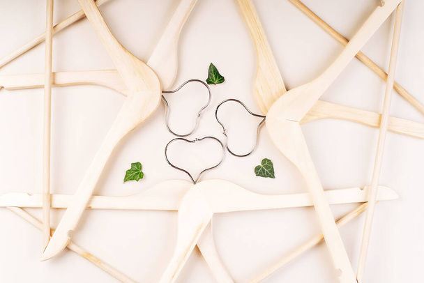 Hangers with plants on white background with copy space.Conscious and environmentally friendly consupmtion in shopping.Recycling or zero waste concept.Shopping,sale,promo concept. - Photo, Image
