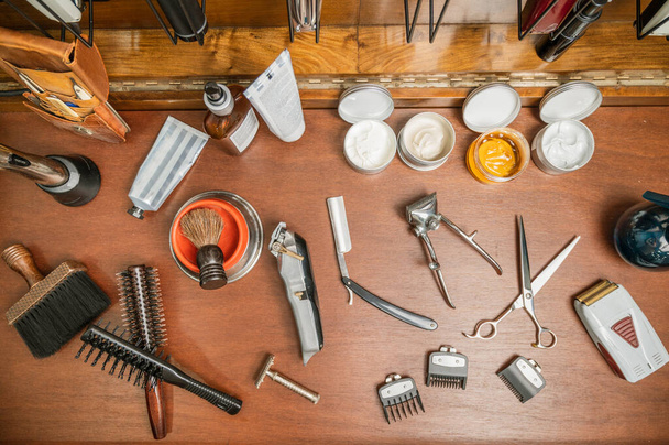 Herramientas de peluquería de vista superior en el estante de la barbería.  - Foto, Imagen
