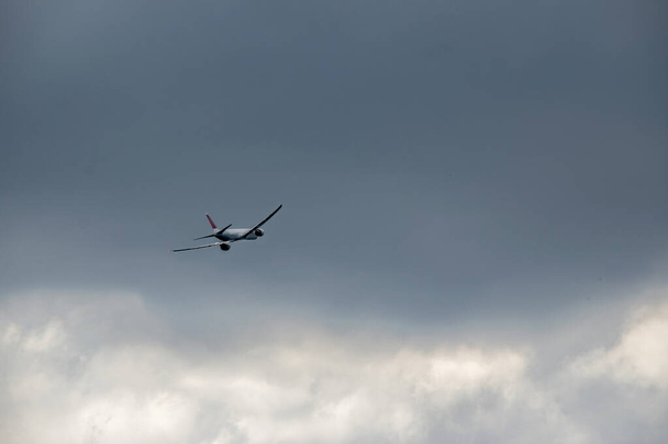 plane flying on a cloudy sky - Foto, afbeelding