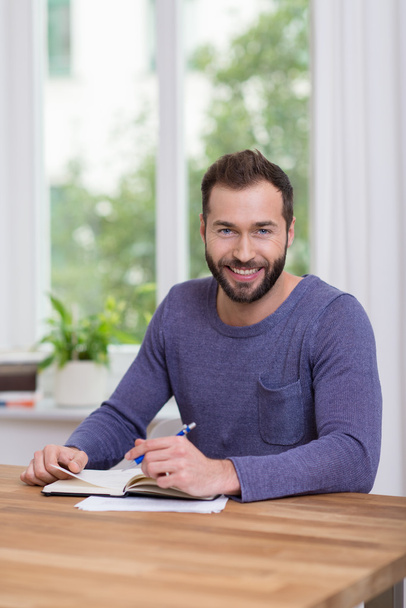 Smiling attractive man working at home - 写真・画像
