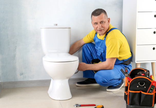 Υδραυλικός εργάζεται στην τουαλέτα - Φωτογραφία, εικόνα