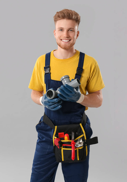 Handsome plumber on grey background - Foto, Imagem