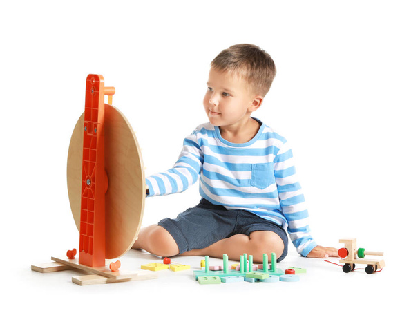Funny little boy playing with wooden toys on white background - Photo, Image