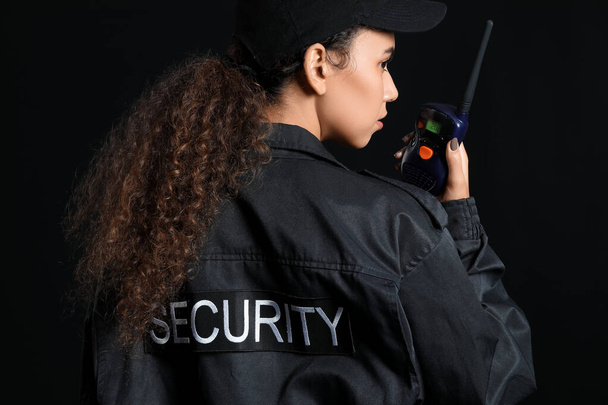 Protector de seguridad afroamericano con transmisor de radio sobre fondo oscuro - Foto, imagen