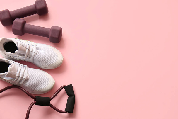 Stylové činky, fitness expandér a boty na růžovém pozadí - Fotografie, Obrázek