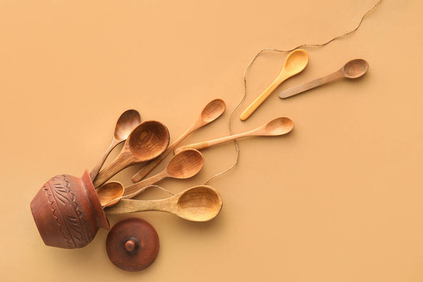 Stylish jug and wooden spoons on beige background - Photo, Image
