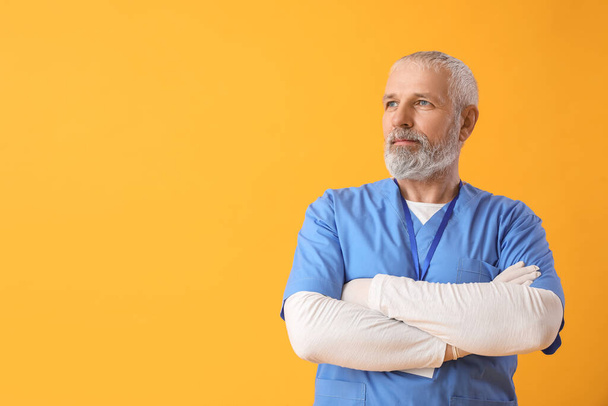 Mature male doctor on yellow background - Fotoğraf, Görsel