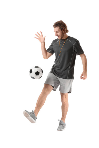 Sporty male coach with soccer ball on white background - Foto, Imagen