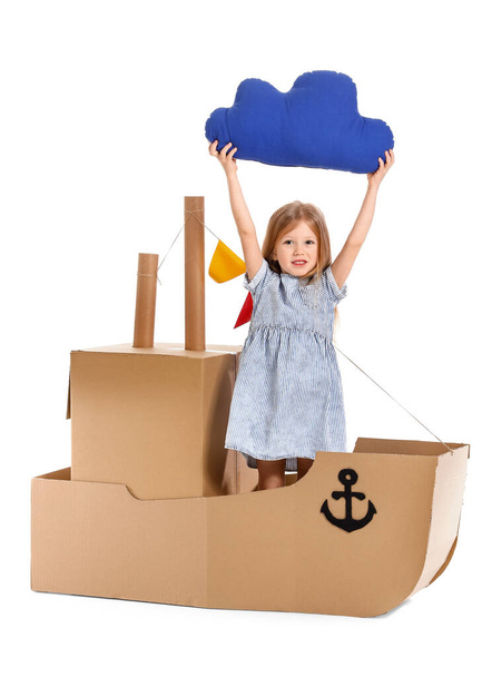 Petite fille mignonne jouant avec le navire en carton sur fond blanc
 - Photo, image