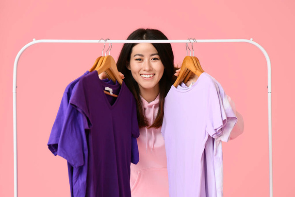 Genç Asyalı kadın ve pembe arka planda t-shirtleri olan göğüsler. - Fotoğraf, Görsel