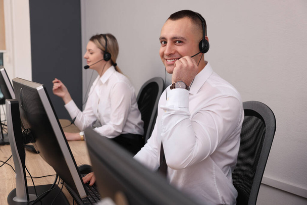 Call center operators with headsets working in modern office - Foto, Imagem