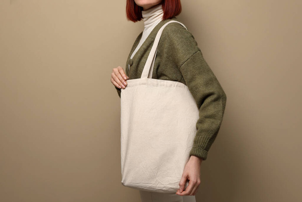 Woman with eco bag on beige background, closeup. Space for text - Zdjęcie, obraz