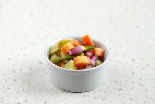 Acar, Side Dish voor kip, vlees of Martabak Dish. Gekleurde wortel en komkommer met groene chili en shallot, Meng met azijn, suiker, zout. Op de witte schaal - Foto, afbeelding