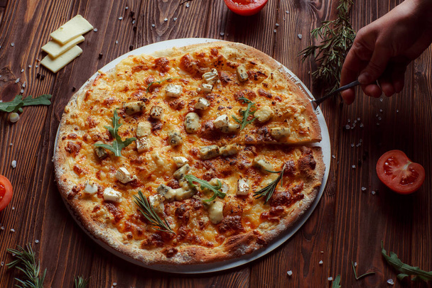 pizza with meat and vegetables on a wooden table  - Foto, Bild