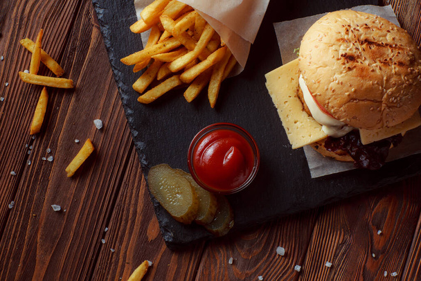 burger z frytkami na drewnianym tle - Zdjęcie, obraz