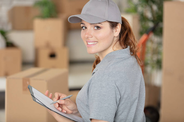 delivery woman in uniform holding package - Foto, imagen