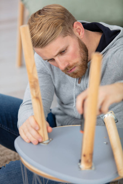 young man repairing furniture at home - Fotoğraf, Görsel