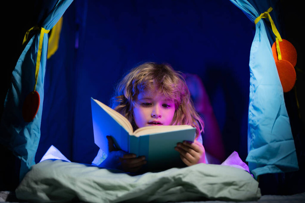 Child reading book. Kids bedtime. Boy read book in bed. - Foto, Imagen
