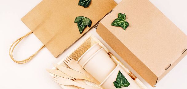 Eco craft paper tableware,cups,fast food containers.Recycling,eco-friendly concept.Disposable eco cutlery,plates,spoons,knives,forks on a light background.Craft paper bag for food delivery.Copy space. - Photo, Image