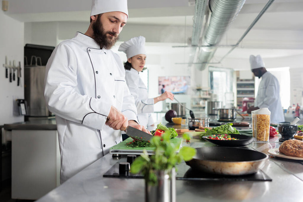 Gastronomie chef-kok in restaurant keuken bereiden van plantaardige garnering voor gastronomische gerechten geserveerd tijdens het diner service. - Foto, afbeelding