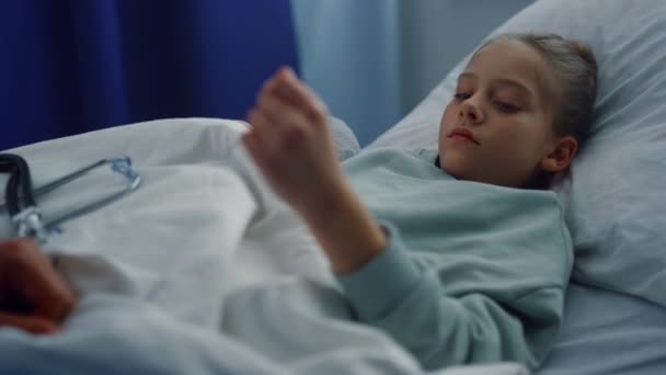 Järkyttynyt tyttö makaa sairaalassa sängyssä lääkärintarkastuksessa osastolla muotokuva. - Materiaali, video