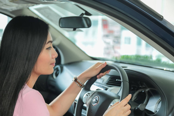Asian girl smiling  relaxing sitting and prepare drive safety in new car - Foto, immagini