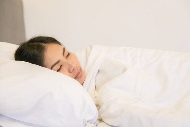 Beautiful woman sleeping on white pillow in bedroom - Foto, afbeelding