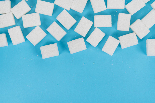Natürliche weiße Zuckerwürfel isoliert auf blauem Hintergrund - Foto, Bild