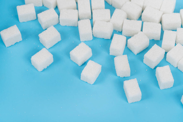 Cubos naturais de açúcar branco isolados sobre fundo azul - Foto, Imagem