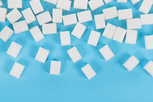 Natural white sugar cubes isolated on blue background - Fotoğraf, Görsel
