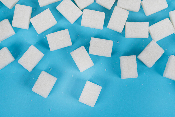 Natürliche weiße Zuckerwürfel isoliert auf blauem Hintergrund - Foto, Bild