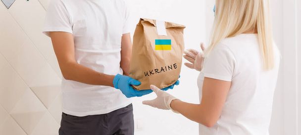 un uomo tiene una scatola con l'aiuto umanitario in Ucraina - Foto, immagini