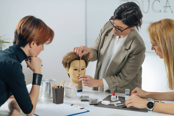 Permanent eyebrow training course. Female cosmetologist with adult students in cosmetology education center - Photo, Image