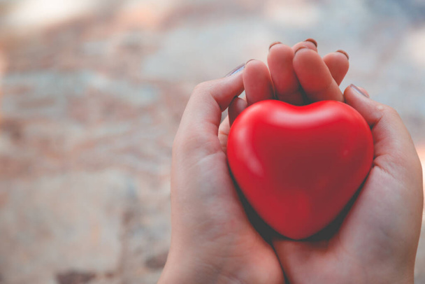 Nő tart piros szív használata a háttér - Fotó, kép
