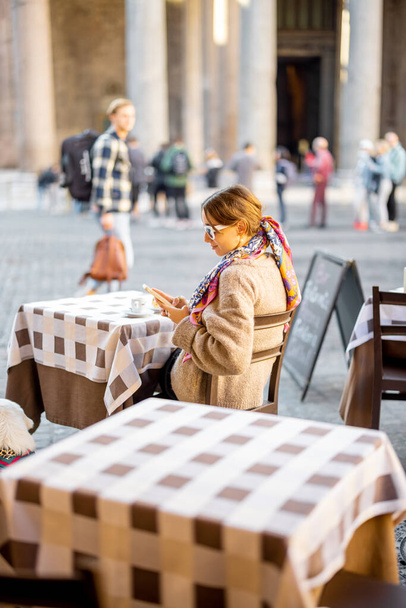 ローマのパンテオン寺院近くの屋外カフェに座っている女性 - 写真・画像