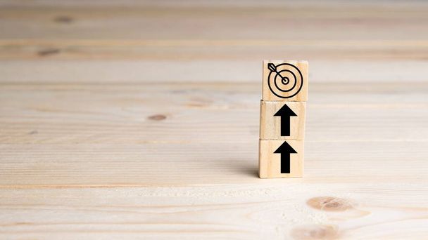 Up arrows and a target with arrow in the center on wooden blocks. Concept of personal growth, growth of a business. copy-space - Photo, Image