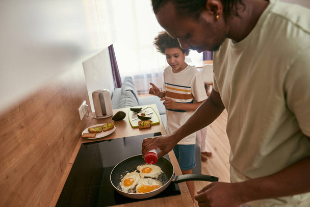 Side view of black family cook breakfast at home - Foto, Imagen