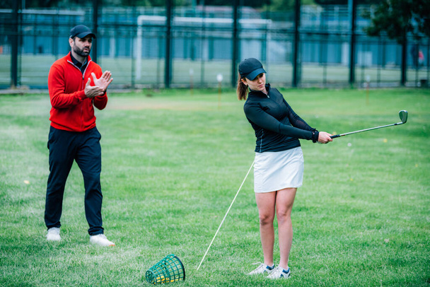 Golf hocası genç bir kadınla çalışıyor. Salıncak geliştirme üzerine. - Fotoğraf, Görsel