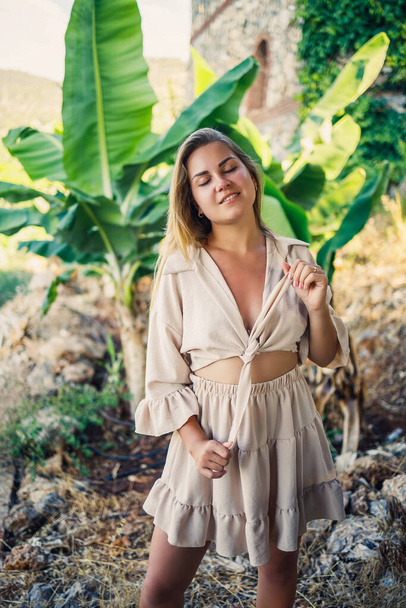 Приваблива молода чесна жінка стоїть біля бананових дерев у тропічному парку
. - Фото, зображення
