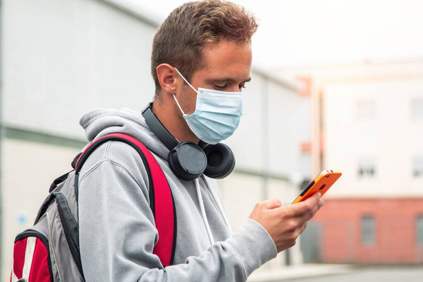 student with medical mask and mobile phone - 写真・画像