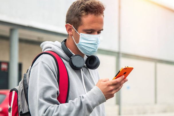 student with medical mask and mobile phone - Fotó, kép