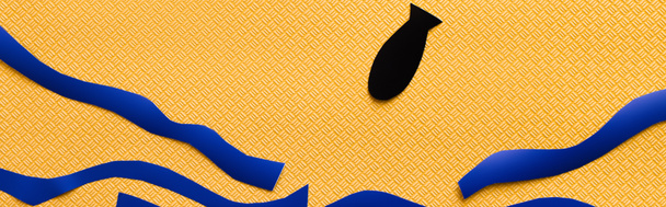 Vista superior de la bomba de papel cerca del mar de cartón abstracto sobre fondo amarillo texturizado, pancarta  - Foto, imagen